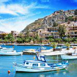 Traditional greek fishing boat with Palamidi castle in background in Nafplio, Greece. Stitched image.
